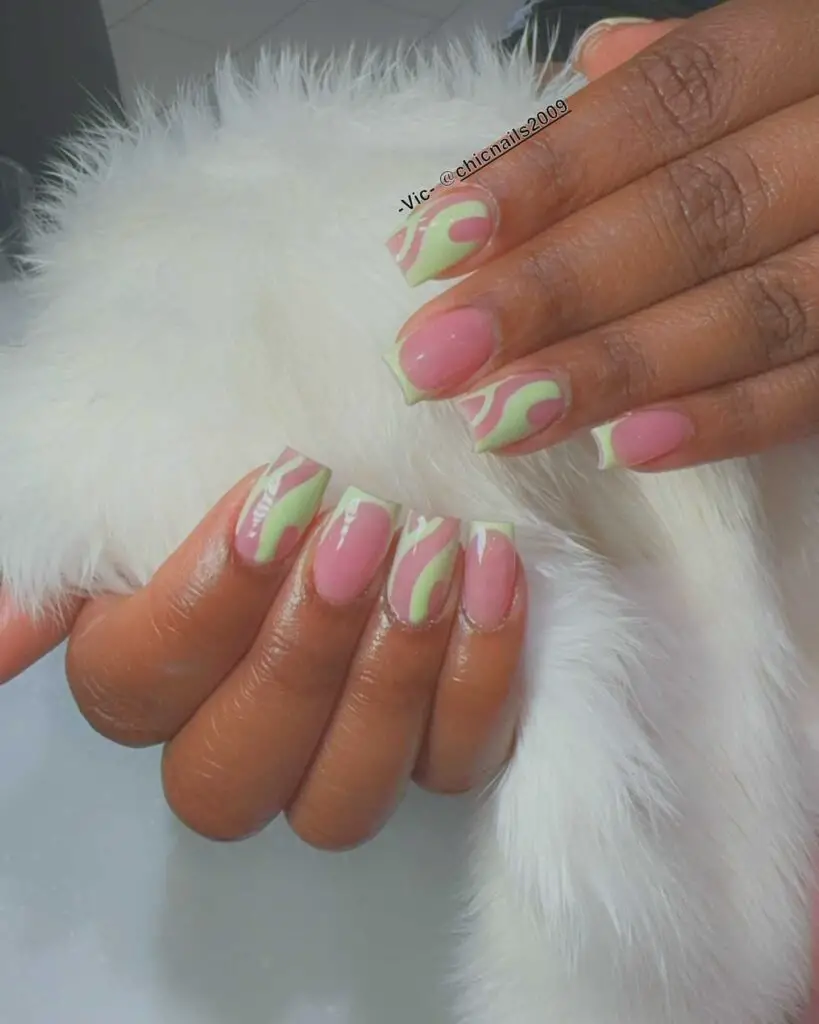 Bright pink nails with playful neon green swirls, putting a vibrant spin on the traditional French manicure.