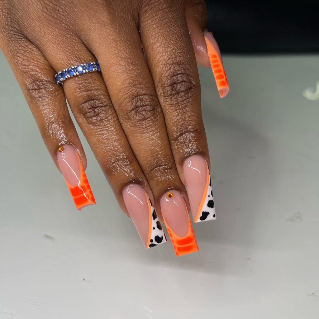 Cow Print Chic: Nude Nails with Orange French Tips