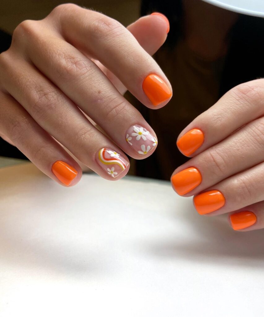 Floral Finesse: Orange Nails with Flower Accents