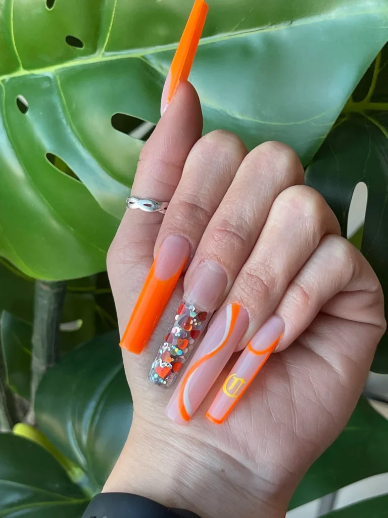 Tropical Twist: Bright Orange Nails with Artistic Detailing