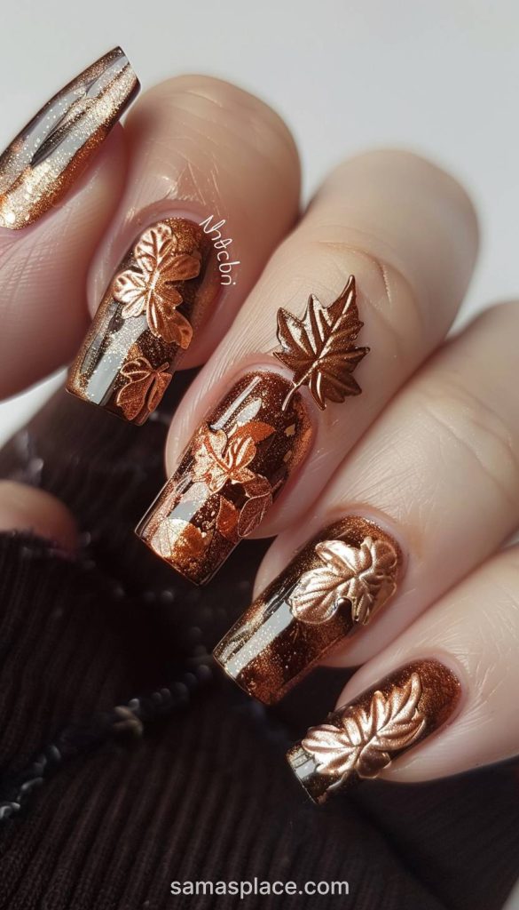 Bright orange nails with black leaf patterns are bold and festive, making them a fun option for fall.